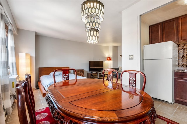 dining area with light tile patterned floors and a notable chandelier