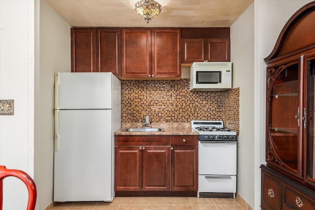 kitchen featuring light stone countertops, sink, white appliances, decorative backsplash, and light tile patterned flooring