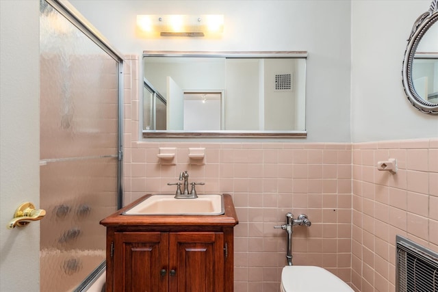 full bathroom with vanity, toilet, tile walls, and heating unit