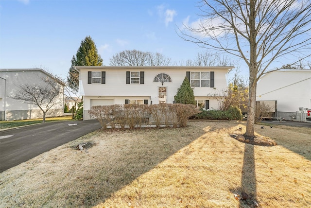 bi-level home featuring a garage and a front lawn