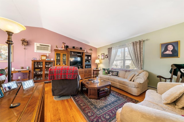 living room featuring a wall mounted air conditioner, wood-type flooring, baseboard heating, and lofted ceiling