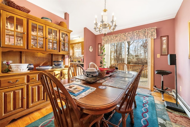 dining space with a notable chandelier and light hardwood / wood-style flooring