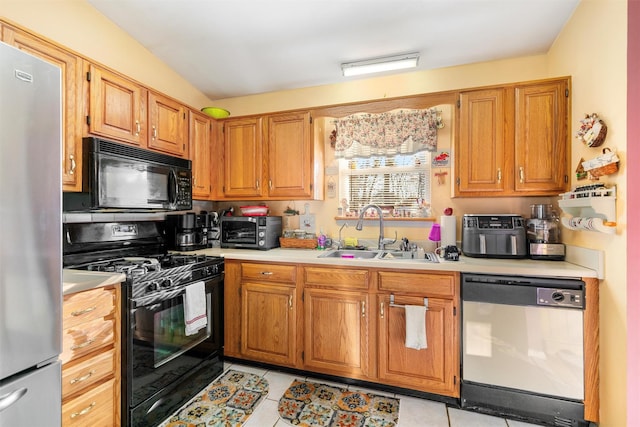 kitchen with light tile patterned flooring, sink, and black appliances