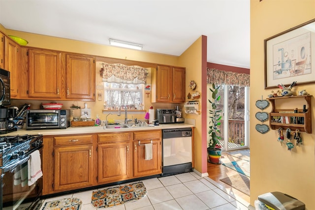 kitchen with gas range, stainless steel dishwasher, a wealth of natural light, and sink