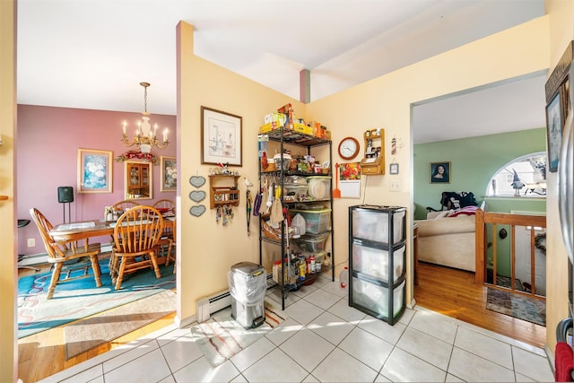 dining space featuring a notable chandelier, light hardwood / wood-style floors, and a baseboard radiator