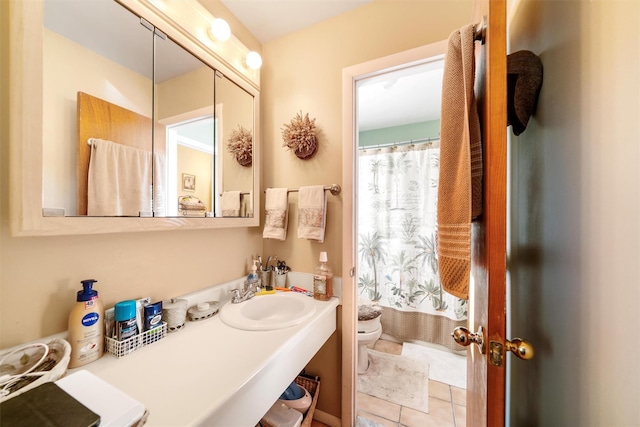 bathroom with tile patterned flooring, toilet, and sink