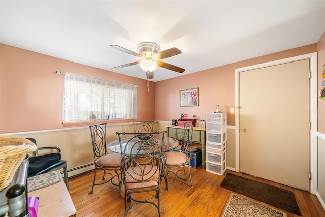 dining room with baseboard heating, light hardwood / wood-style flooring, and ceiling fan