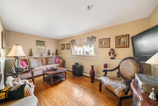 living room with wood-type flooring, a wall mounted air conditioner, and a baseboard heating unit