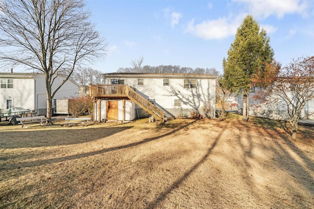 back of property featuring a yard and a wooden deck