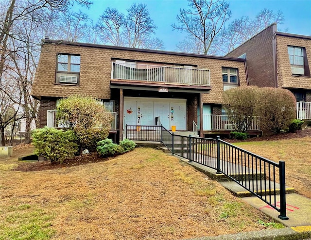 townhome / multi-family property with a balcony and a front yard