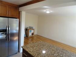 kitchen with light stone countertops, stainless steel fridge, and light hardwood / wood-style floors