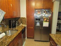 kitchen featuring stone counters, sink, and stainless steel appliances