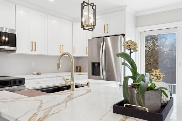 kitchen with light stone counters, sink, stainless steel appliances, and decorative light fixtures