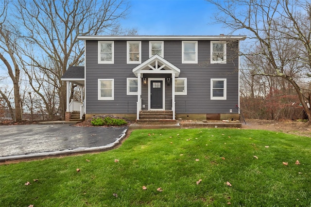 colonial house featuring a front lawn