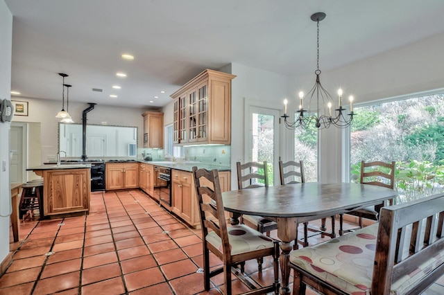 kitchen featuring sink, an inviting chandelier, hanging light fixtures, light brown cabinets, and kitchen peninsula