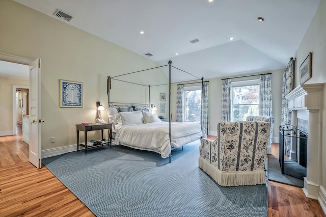 bedroom with lofted ceiling and wood-type flooring