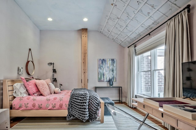 bedroom with wood-type flooring and vaulted ceiling