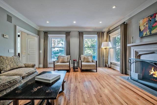 living room with ornamental molding and light hardwood / wood-style flooring