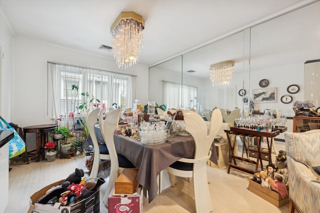 dining area with an inviting chandelier and light hardwood / wood-style flooring