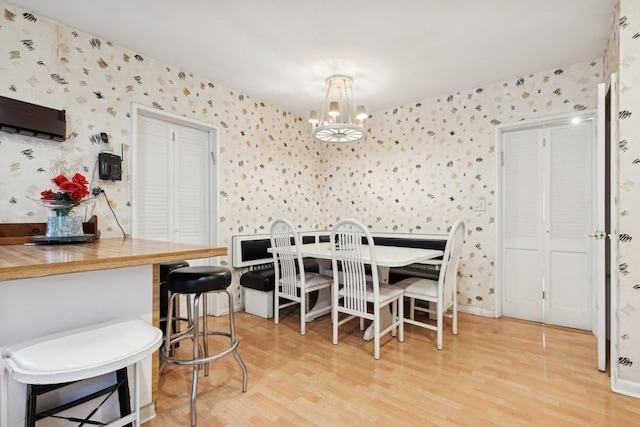 dining space featuring light wood-type flooring and an inviting chandelier