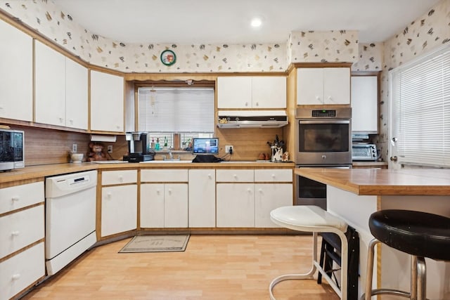 kitchen with white cabinetry, sink, light wood-type flooring, and appliances with stainless steel finishes