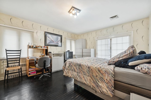 bedroom with dark wood-type flooring and multiple windows