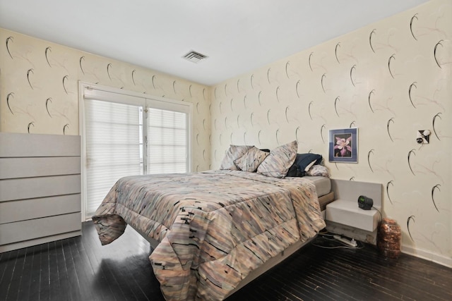 bedroom with dark hardwood / wood-style floors