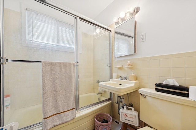 full bathroom with sink, enclosed tub / shower combo, tile walls, and toilet