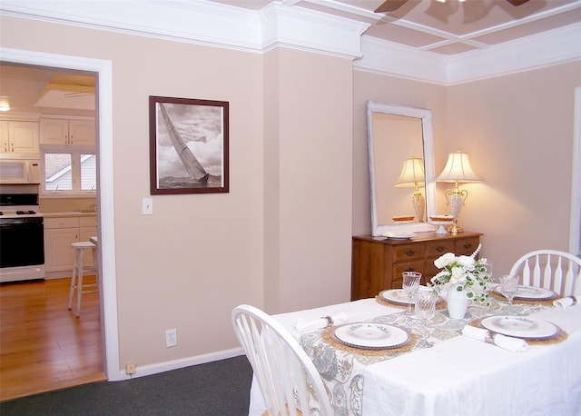 dining space with crown molding and hardwood / wood-style flooring