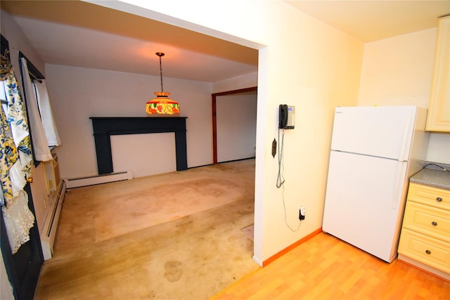 kitchen featuring white refrigerator, a baseboard radiator, light hardwood / wood-style flooring, and hanging light fixtures