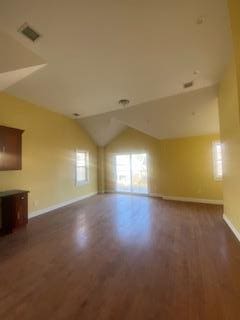 unfurnished living room with dark hardwood / wood-style floors and lofted ceiling