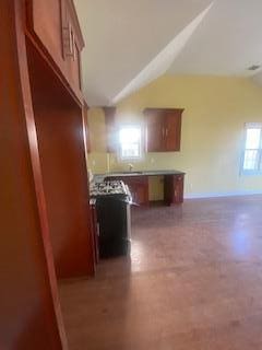 kitchen featuring lofted ceiling and concrete flooring