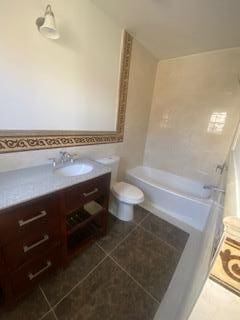 bathroom featuring tile patterned flooring, vanity, and toilet