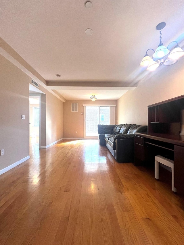 living room featuring a chandelier and light wood-type flooring