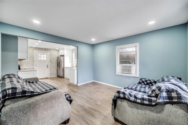 bedroom featuring stainless steel refrigerator, light hardwood / wood-style flooring, and sink