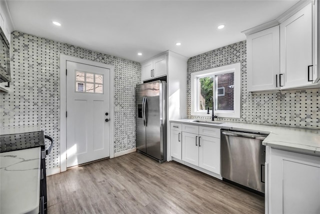 kitchen featuring sink, white cabinets, light wood-type flooring, and appliances with stainless steel finishes