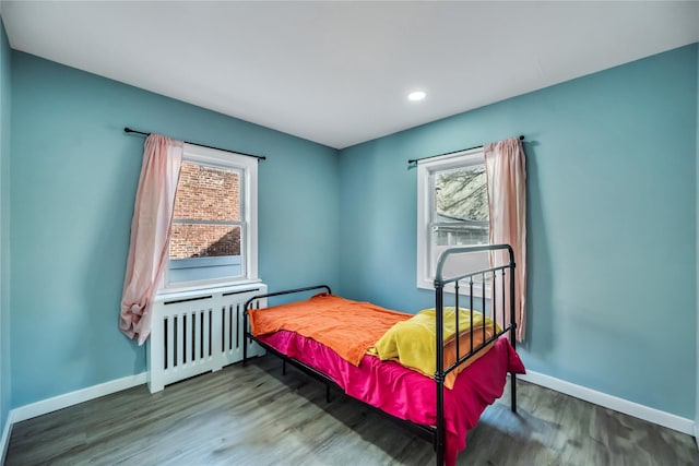 bedroom featuring radiator and hardwood / wood-style flooring