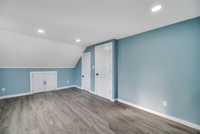 bonus room with light hardwood / wood-style floors and lofted ceiling