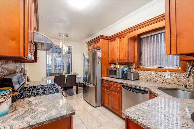 kitchen featuring light stone countertops, sink, crown molding, decorative backsplash, and appliances with stainless steel finishes