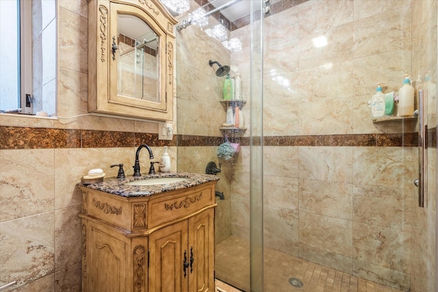 bathroom featuring vanity, a shower with shower door, and tile walls