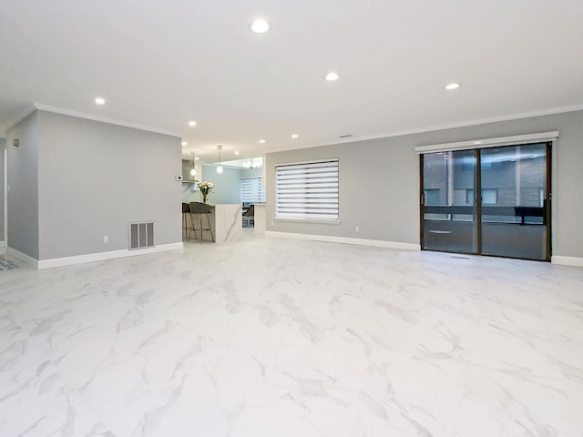 unfurnished living room featuring ornamental molding and a wealth of natural light