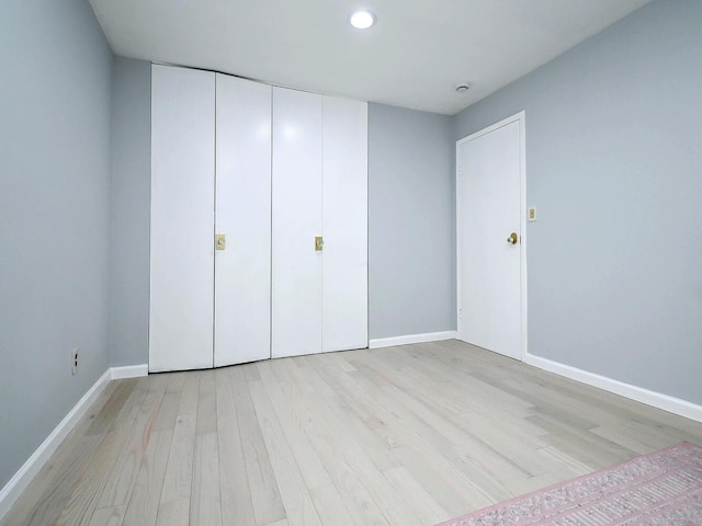 unfurnished bedroom with a closet and light hardwood / wood-style floors