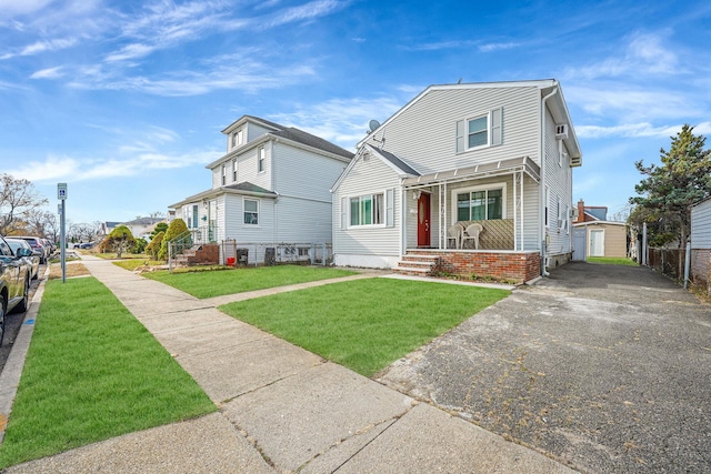 view of front of home with a garage, an outdoor structure, and a front yard