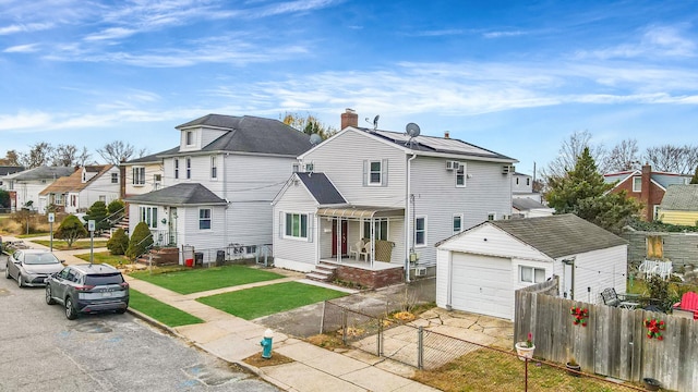 view of front facade with an outbuilding, a front yard, and a garage