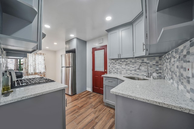 kitchen featuring stainless steel fridge, light hardwood / wood-style flooring, gray cabinetry, and sink