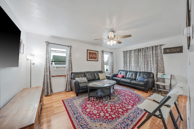 living room featuring ceiling fan, a wealth of natural light, and light hardwood / wood-style flooring