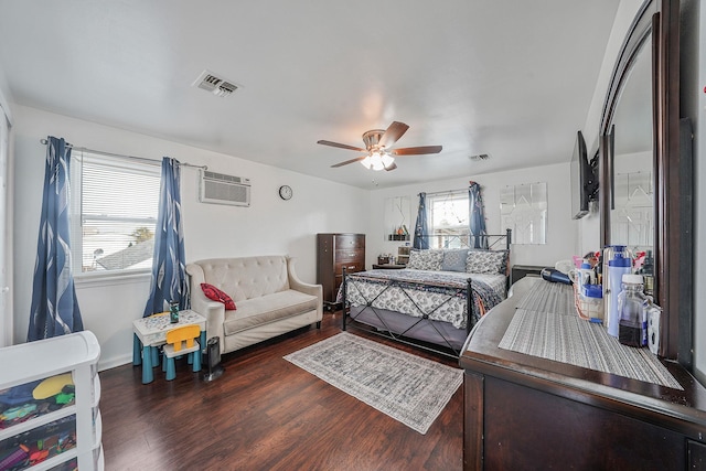 bedroom featuring hardwood / wood-style flooring, ceiling fan, an AC wall unit, and multiple windows