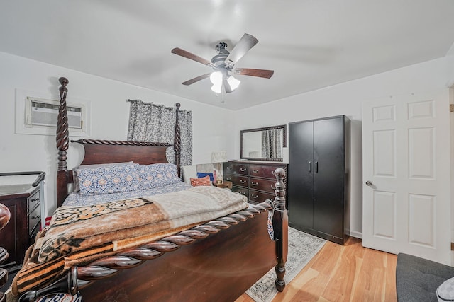 bedroom with light wood-type flooring, a closet, an AC wall unit, and ceiling fan