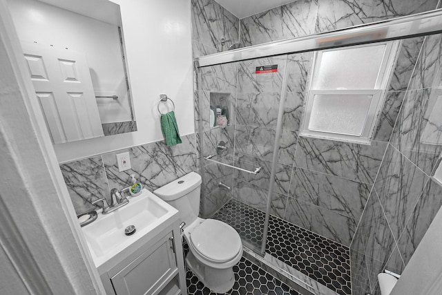 bathroom featuring walk in shower, vanity, tile walls, tile patterned flooring, and toilet