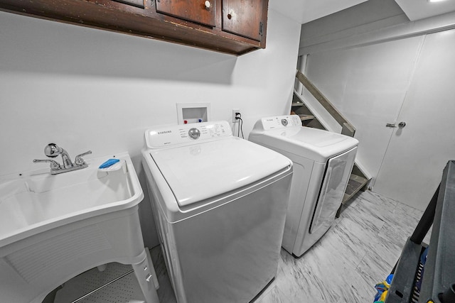 laundry room with washer and clothes dryer, cabinets, and sink